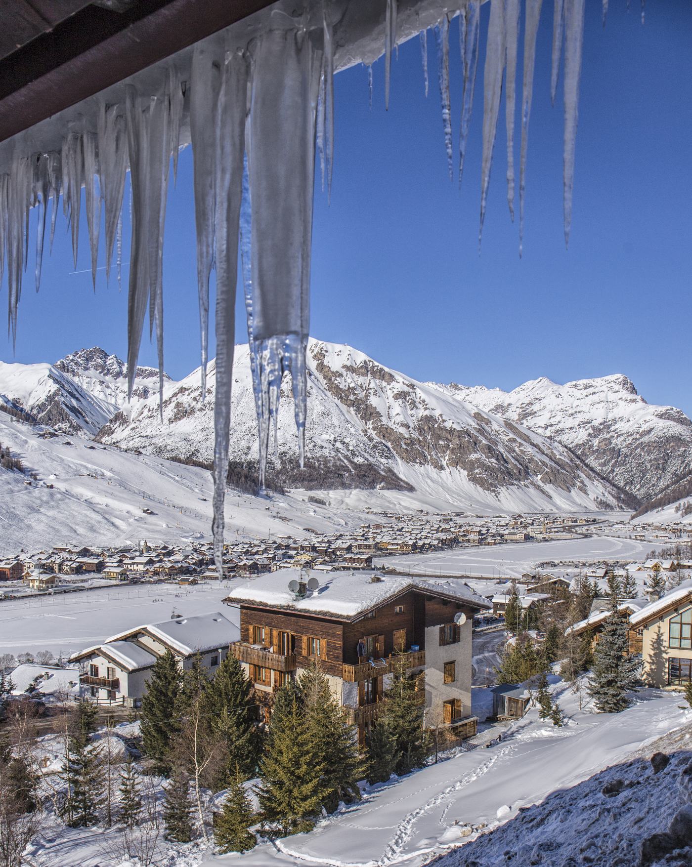 Ghiaccioli con vista sulla vallata innevata di Livigno